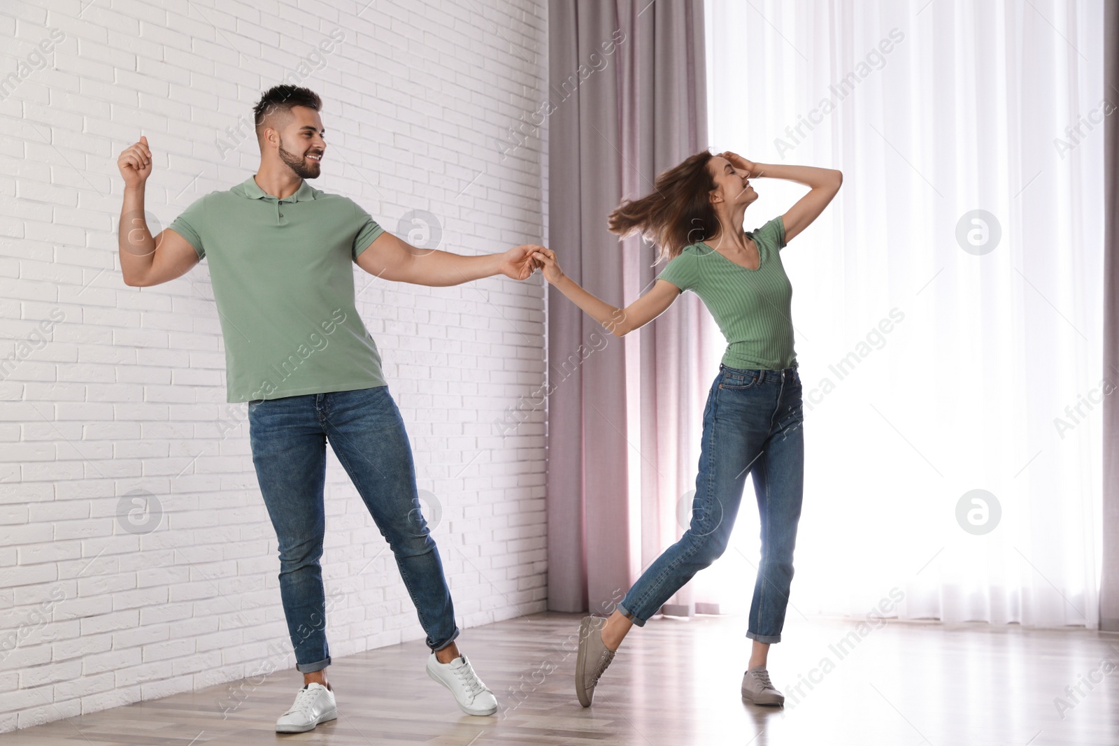 Photo of Lovely young couple dancing together at home