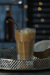 Photo of Glass of iced coffee and coconut on grey table against blurred lights