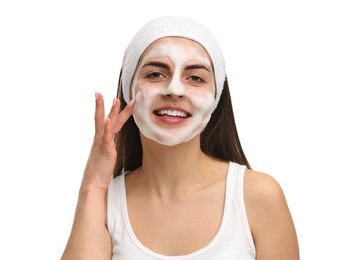 Young woman with headband washing her face on white background