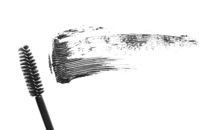 Photo of Smear of mascara and applicator isolated on white, top view