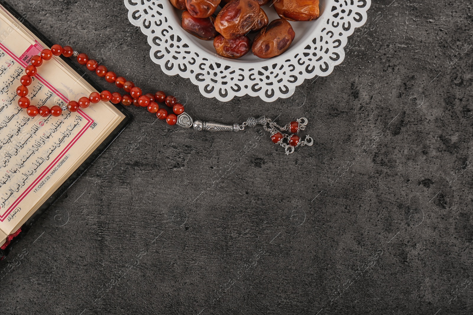 Photo of Flat lay composition with Muslim prayer beads, Quran and space for text on grey background