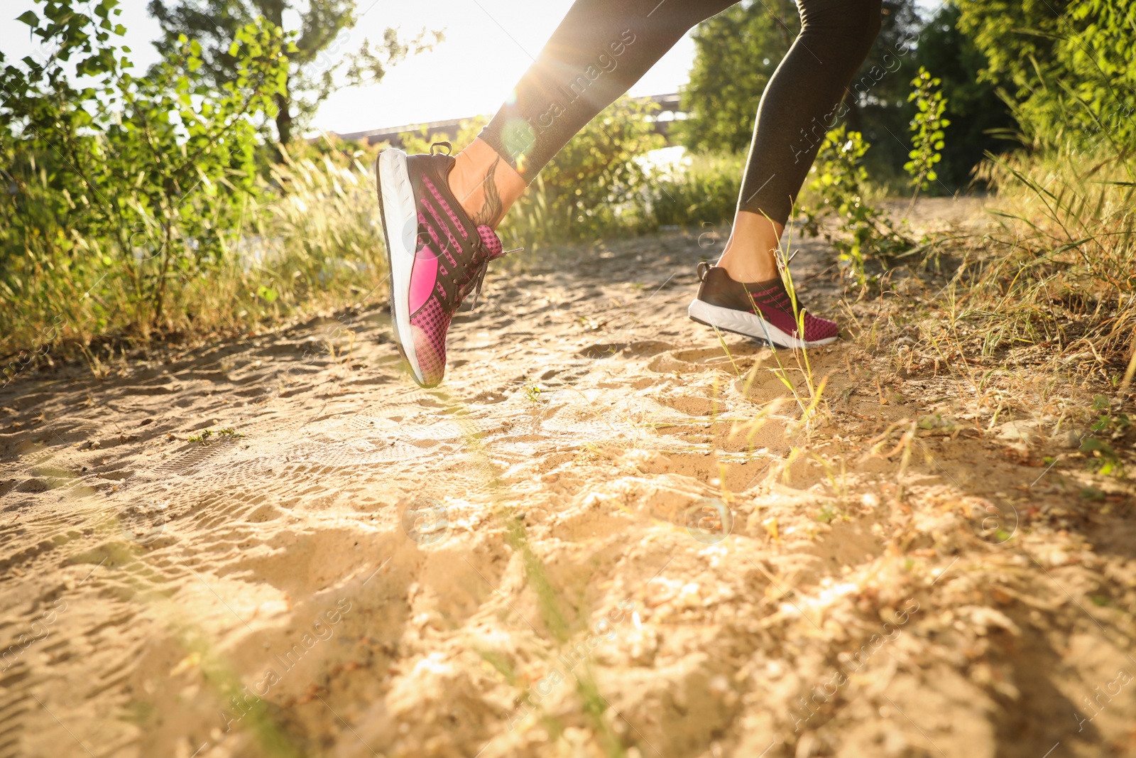 Photo of Young woman running in countryside on sunny day, closeup