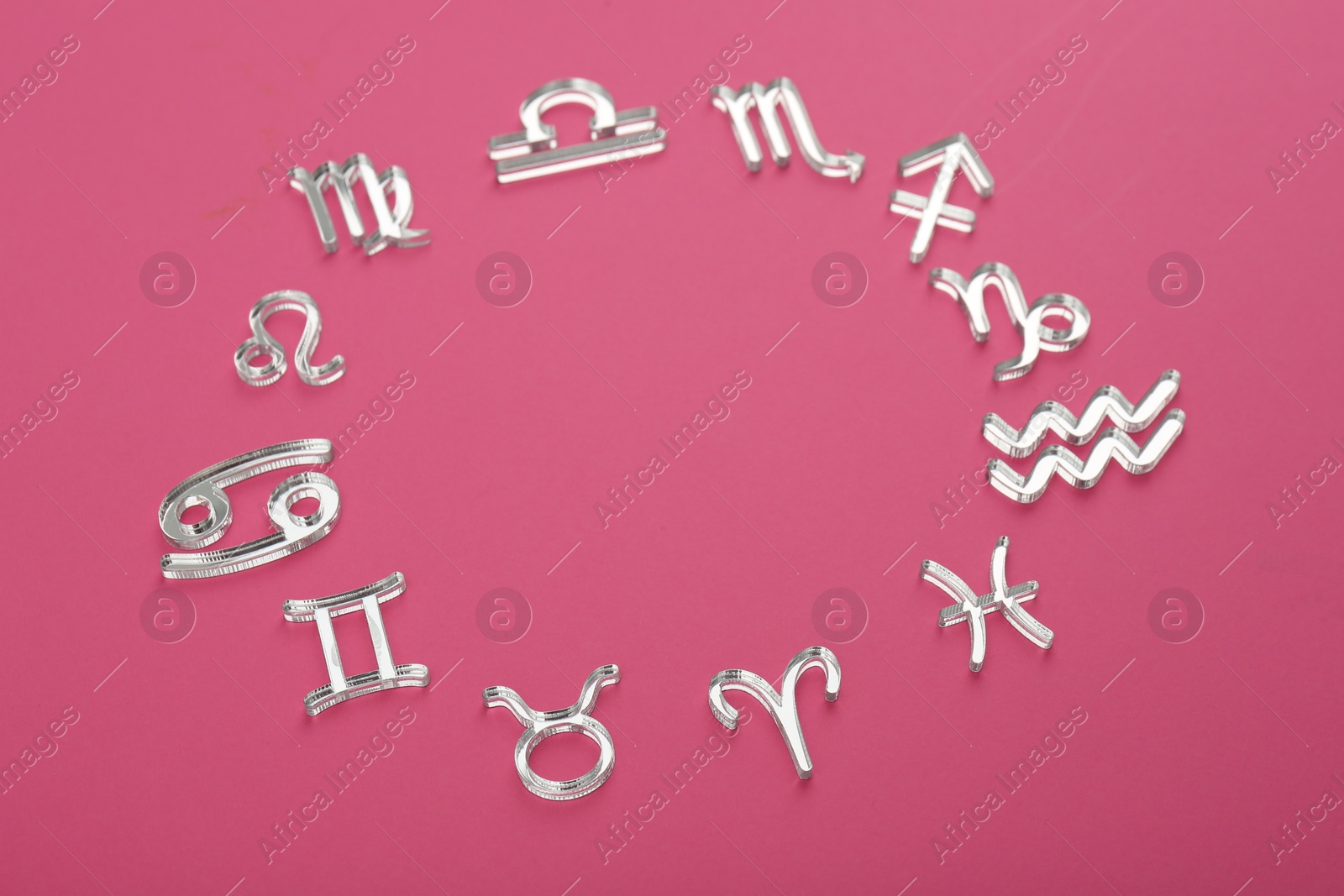 Photo of Zodiac signs on pink background, above view. Space for text