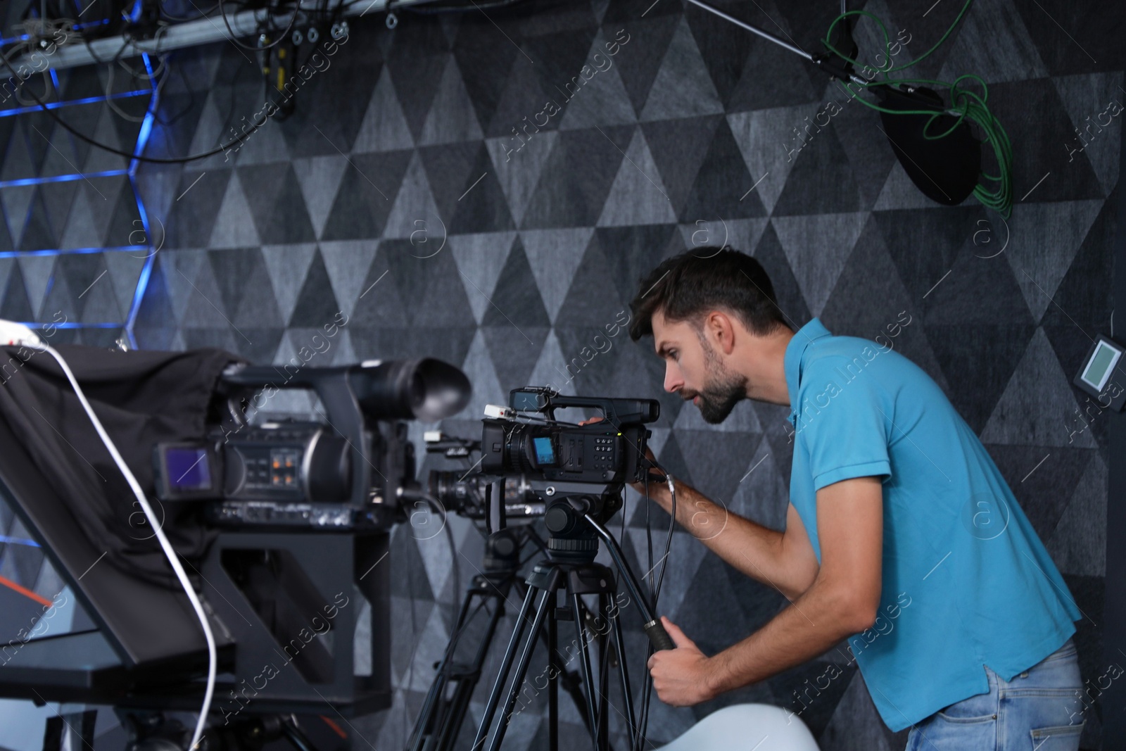 Photo of Professional video camera operator working in studio