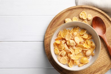Photo of Tasty cornflakes with milk served on white wooden table, top view. Space for text
