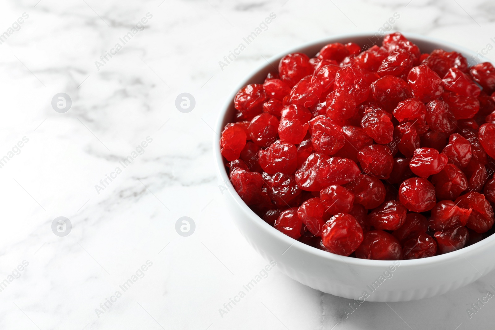 Photo of Bowl of sweet cherries on marble background, space for text. Dried fruit as healthy snack