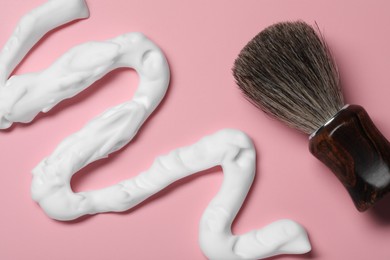 Sample of shaving foam and brush on pink background, flat lay