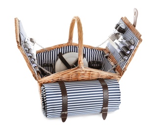 Photo of Wicker basket with picnic essentials and blanket on white background