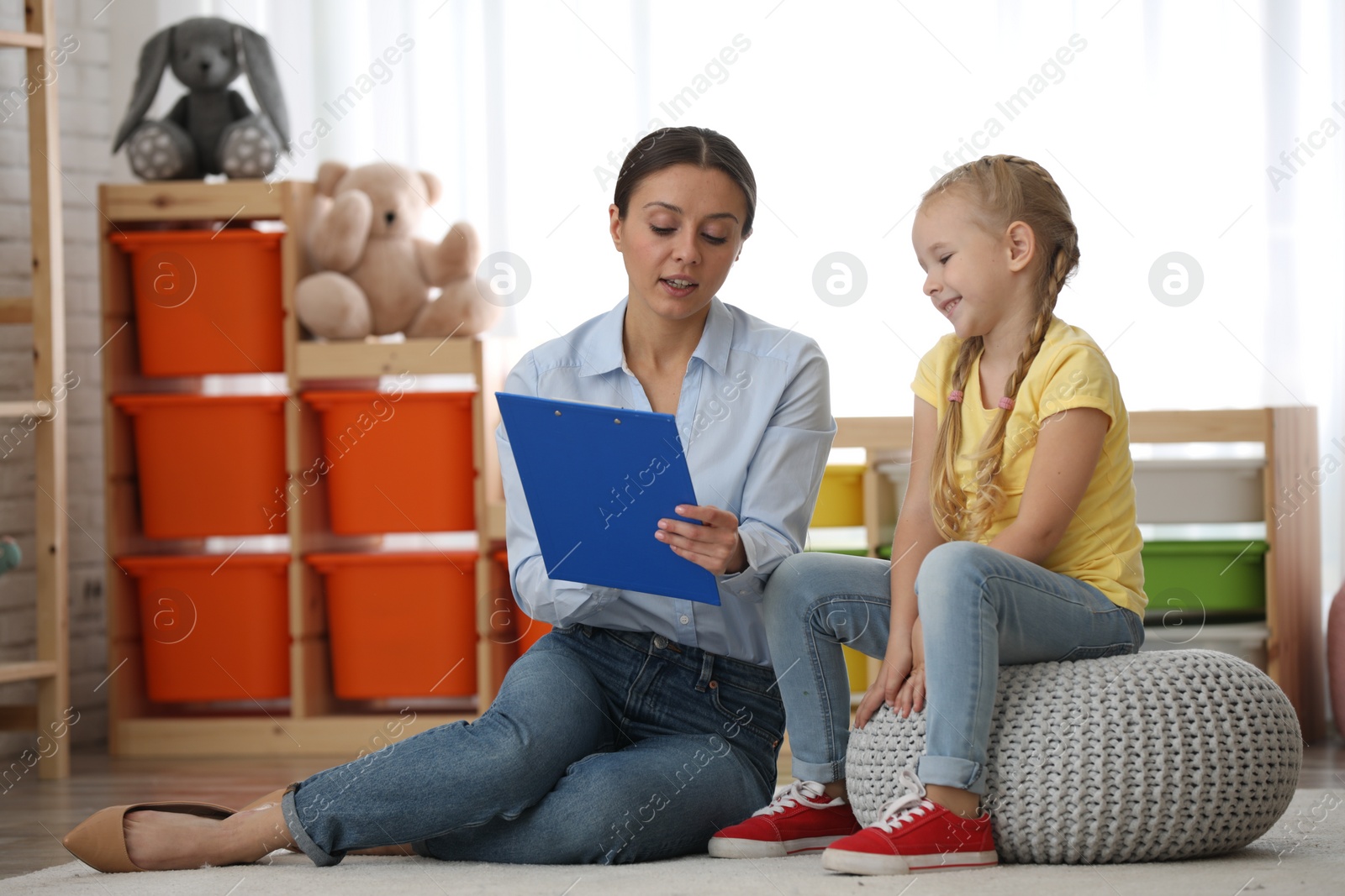 Photo of Child psychotherapist working with little girl in office