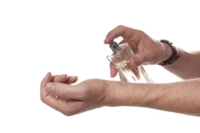 Photo of Man applying perfume on wrist against white background, closeup