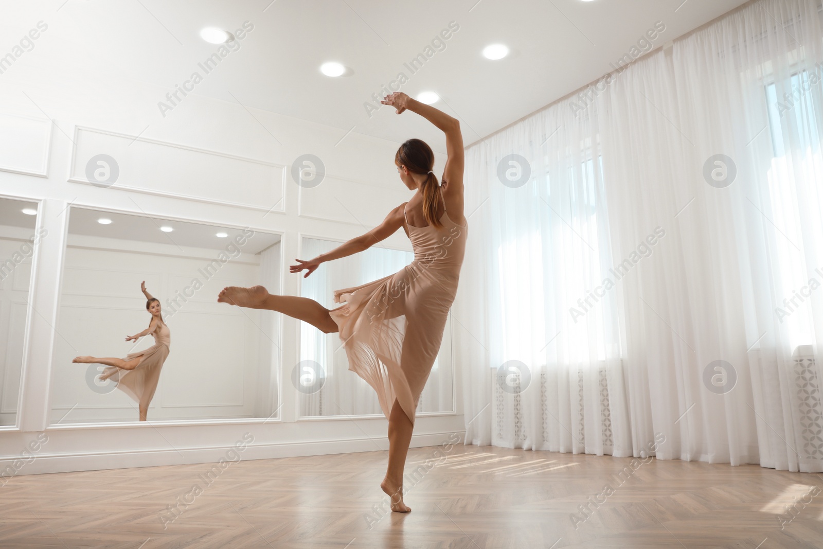 Photo of Beautiful professional dancer practicing moves in studio