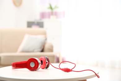 Photo of Stylish headphones on table indoors. Space for text