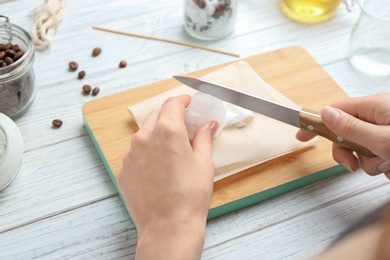 Photo of Woman making coffee candle at wooden table, closeup