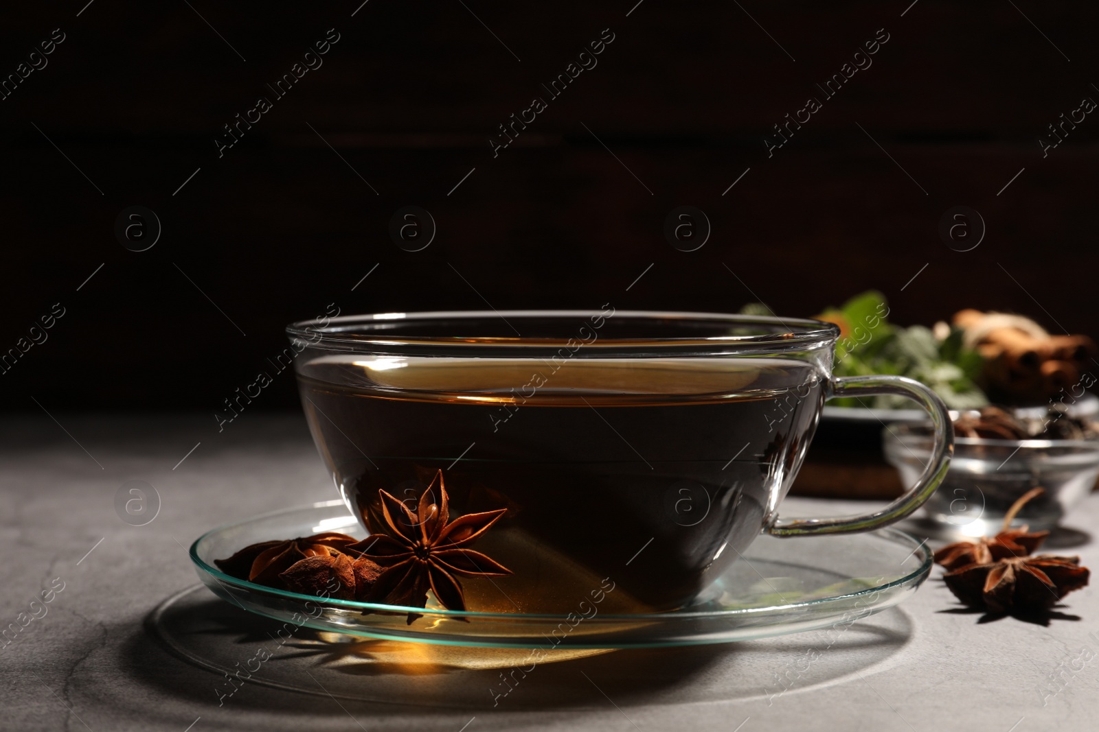 Photo of Aromatic tea with anise stars on light grey table