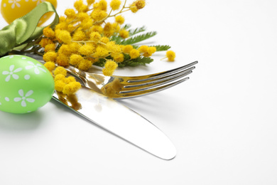 Photo of Cutlery set with floral decor for Easter celebration on white background, closeup