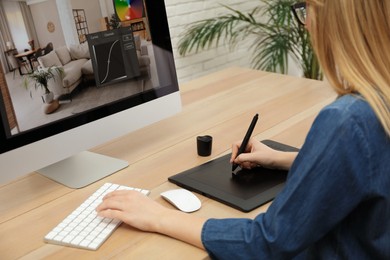 Professional retoucher working on graphic tablet at desk, closeup