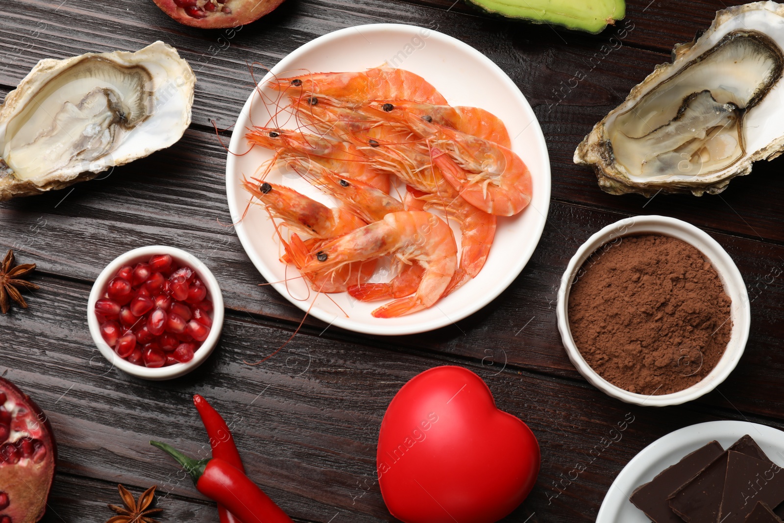 Photo of Natural aphrodisiac. Different food products and red decorative heart on dark wooden table, flat lay