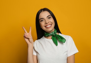 Photo of Young woman wearing stylish bandana on orange background