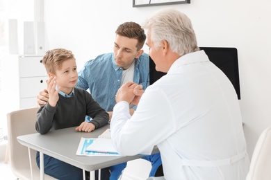 Photo of Young man with his son having appointment at child psychologist office