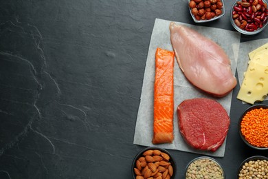 Photo of Different fresh products on black table, flat lay and space for text. Sources of essential amino acids