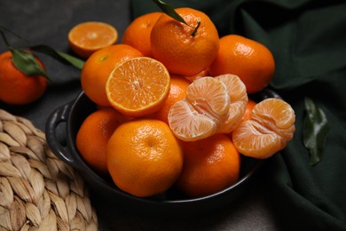 Photo of Bowl of fresh juicy tangerines on black table