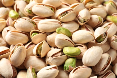 Photo of Many organic pistachio nuts as background, closeup