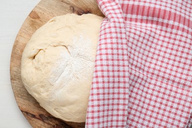 Photo of Fresh yeast dough with flour on white wooden table, top view