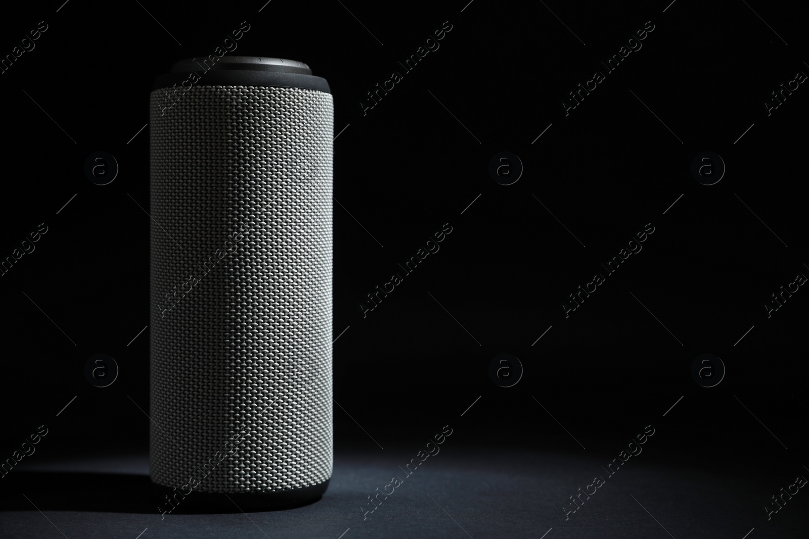 Photo of One portable bluetooth speaker on black background, space for text. Audio equipment