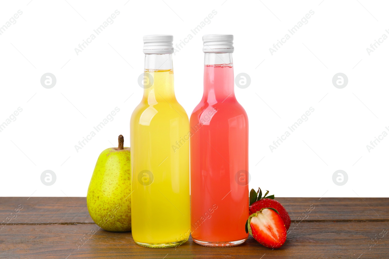 Photo of Delicious kombucha in glass bottles, strawberries and pear on wooden table against white background