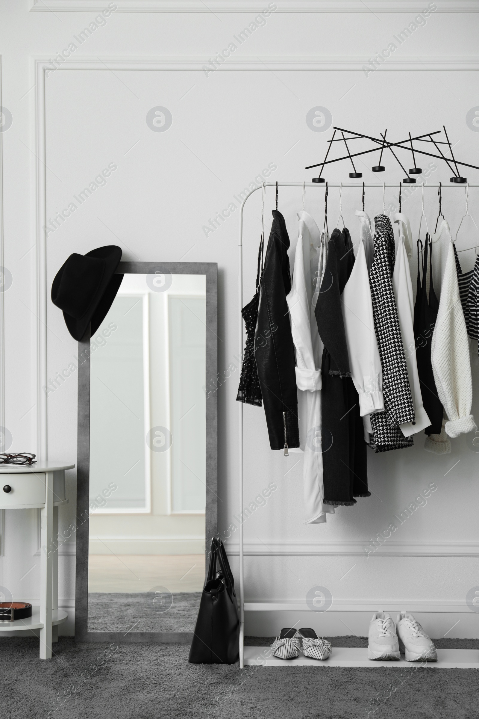 Photo of Rack with stylish clothes in modern dressing room