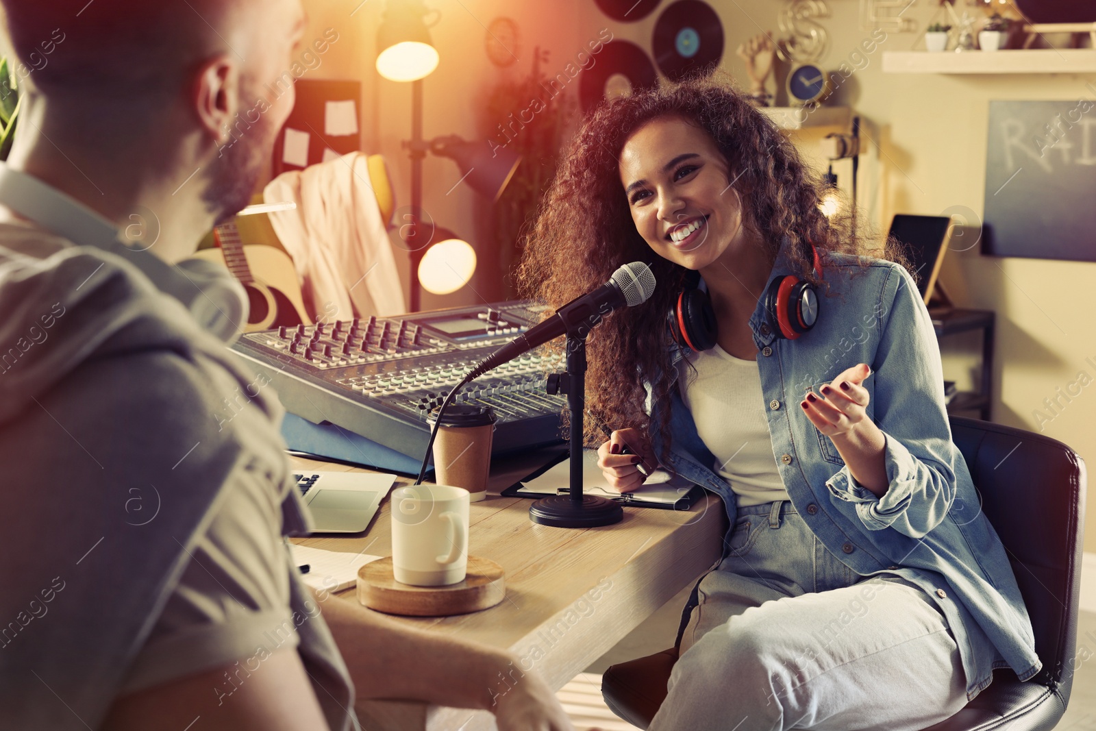 Photo of Young African American woman interviewing man in modern radio studio