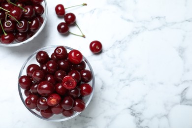 Photo of Sweet juicy cherries on white marble table, flat lay. Space for text