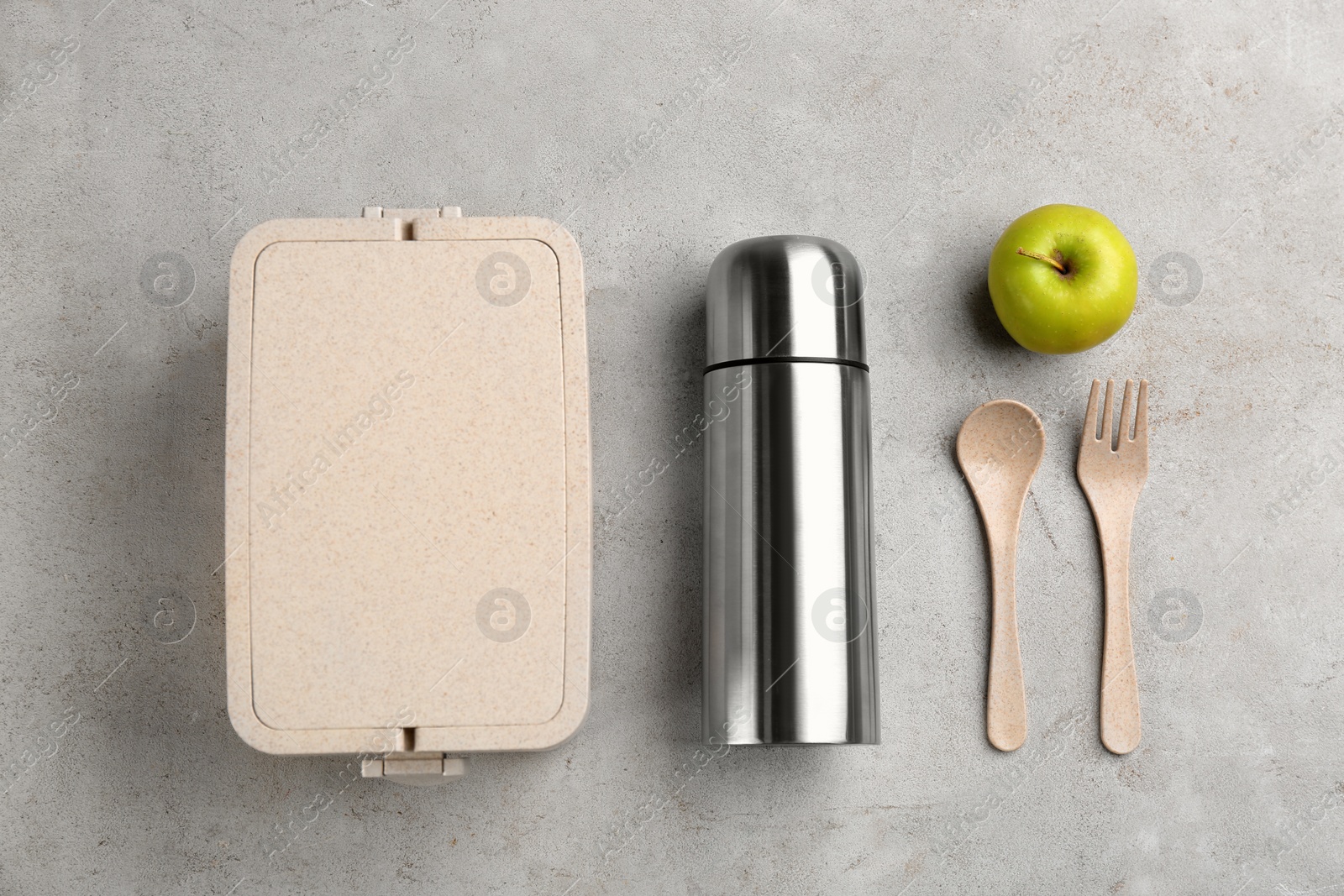 Photo of Thermos, lunch box and apple on light grey table, flat lay