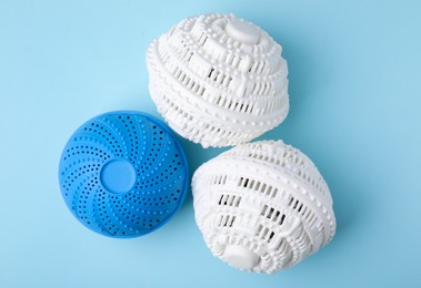 Photo of Dryer balls for washing machine on light blue background, flat lay
