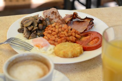 Delicious breakfast with fried meat and vegetables served on beige table