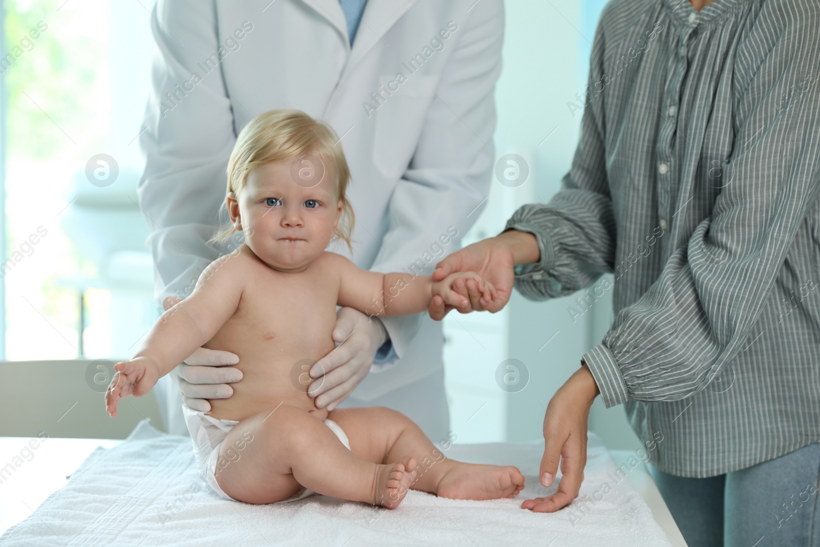 Photo of Mother with her baby visiting pediatrician in hospital. Health growth