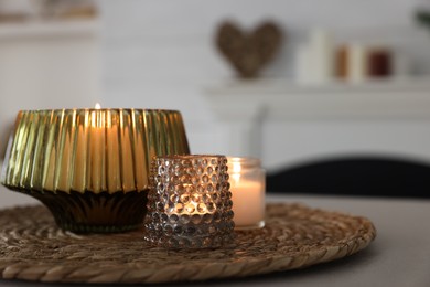 Photo of Burning candles in beautiful glass holders on table indoors, space for text