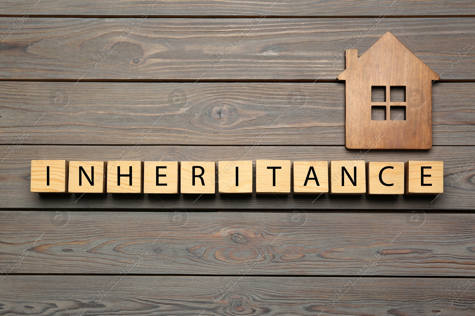 Photo of Word Inheritance made with cubes and house model on wooden background, flat lay