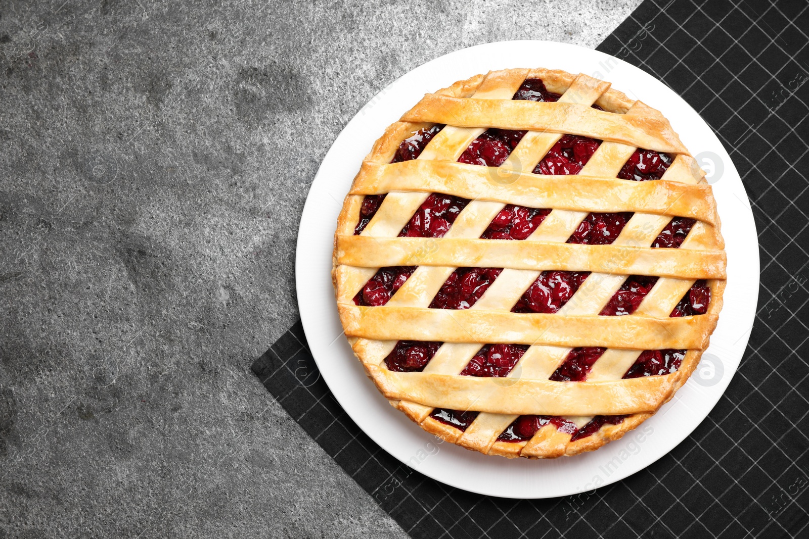 Photo of Delicious fresh cherry pie on grey table, top view. Space for text