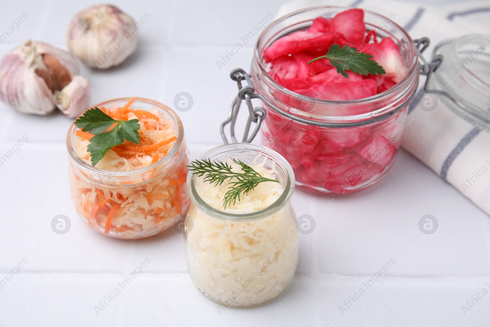 Photo of Delicious sauerkraut prepared according to different recipes on white table