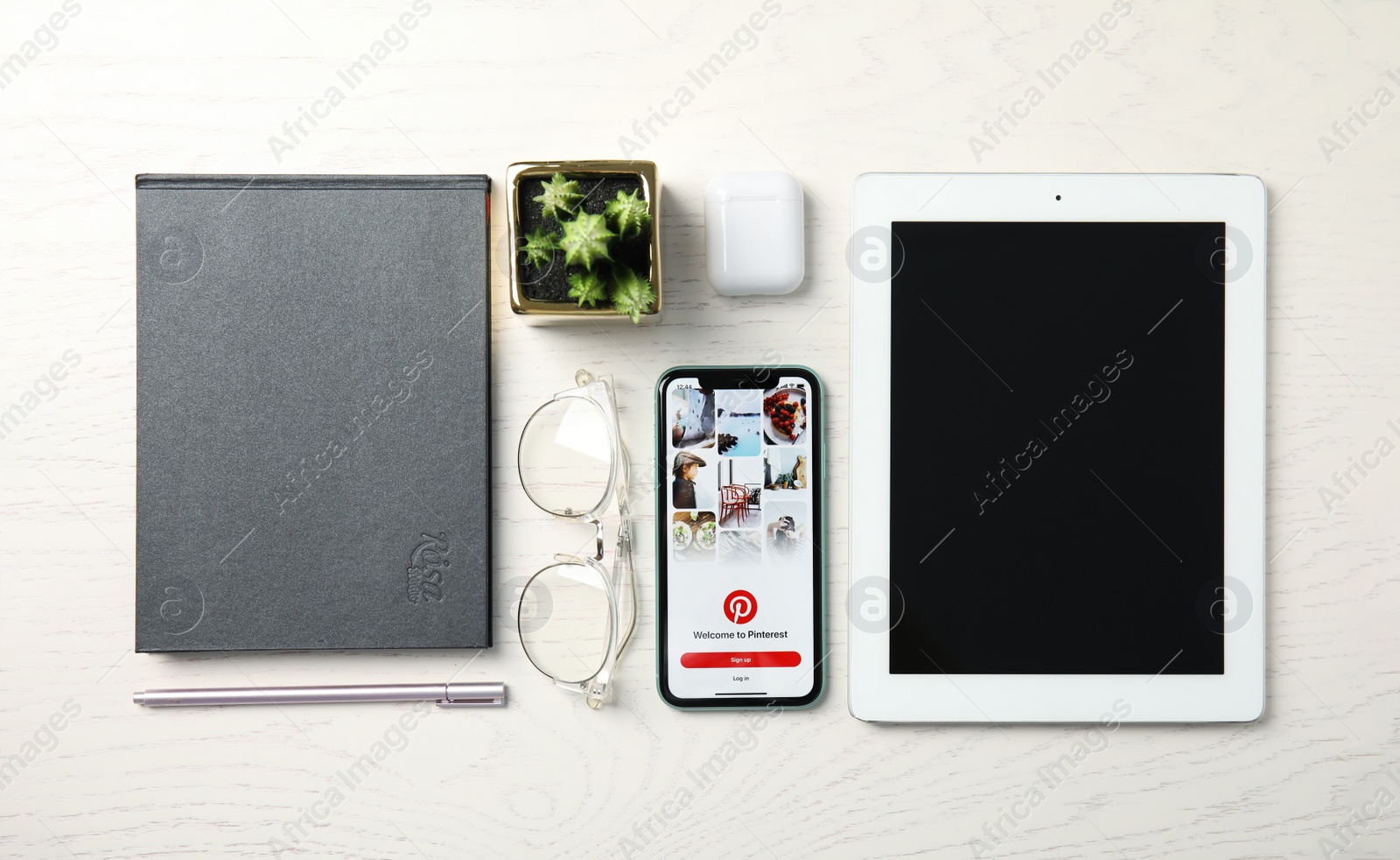 Photo of MYKOLAIV, UKRAINE - JULY 10, 2020: Flat lay composition with Iphone 11, IPad tablet and AirPods on white wooden table