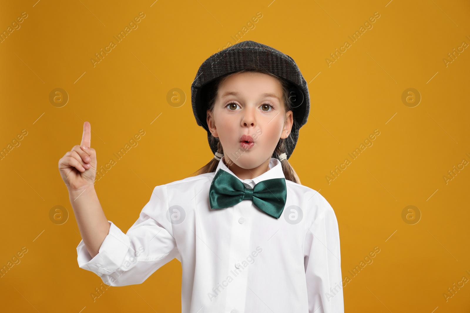 Photo of Cute little detective in hat on yellow background