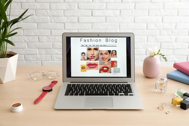 Laptop with open fashion blogger site on table