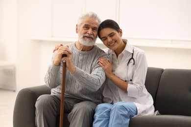 Photo of Health care and support. Smiling nurse with elderly patient in hospital