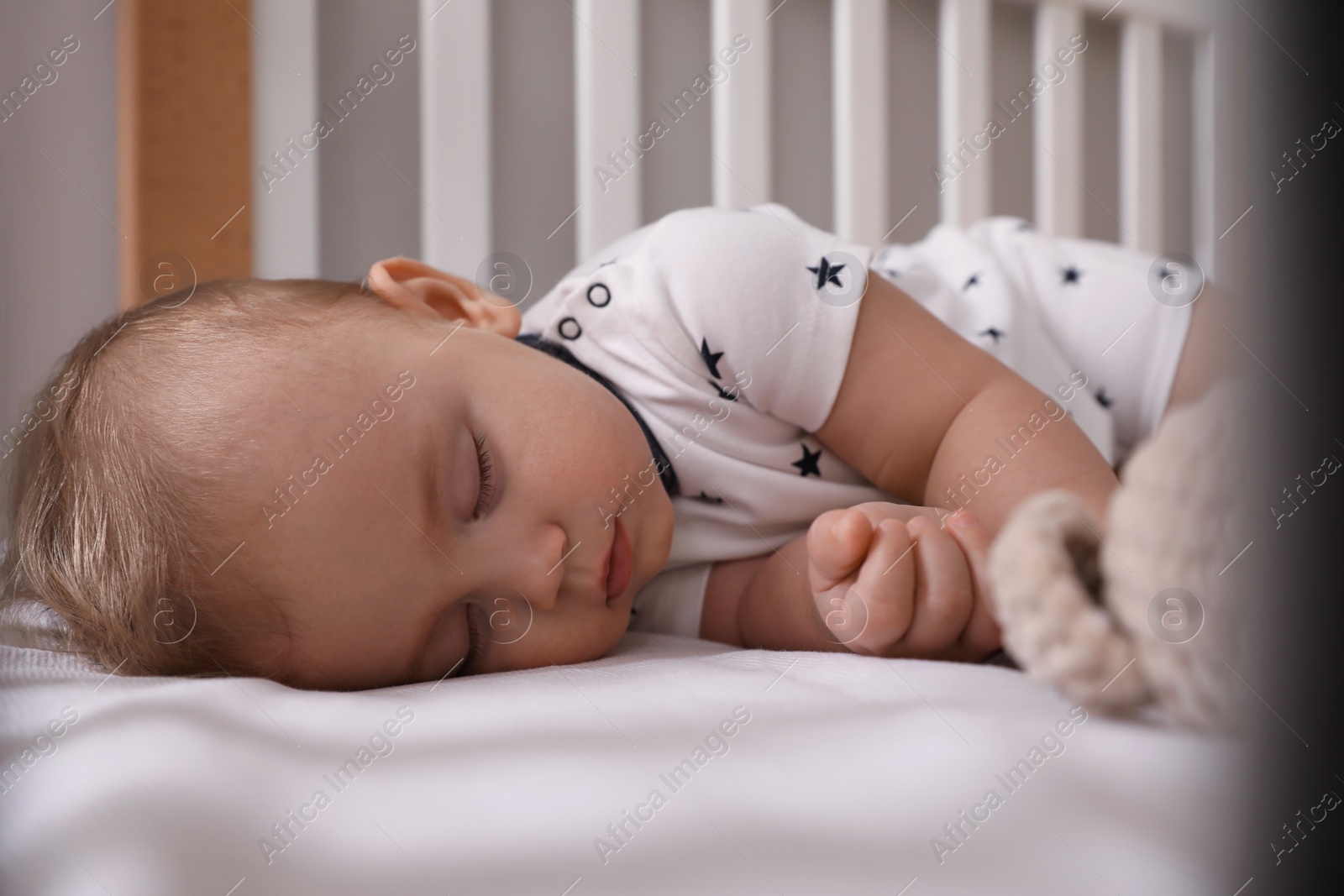 Photo of Adorable little baby sleeping in crib, closeup