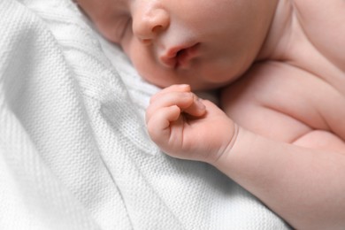 Small cute newborn baby sleeping on white blanket, closeup