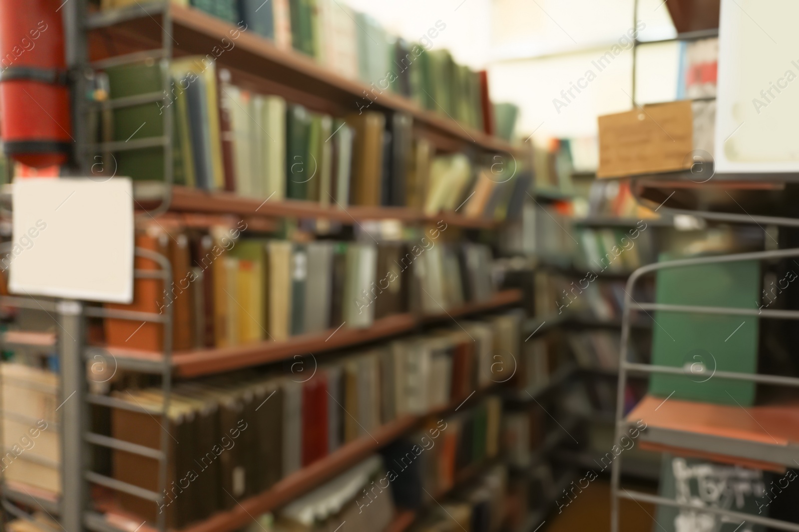 Photo of Blurred view of shelving units with books in library