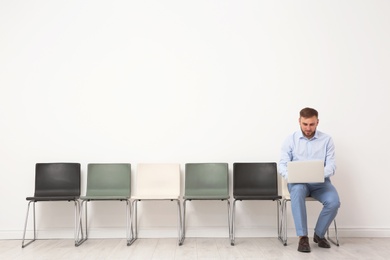 Young man sitting on chair and waiting for job interview