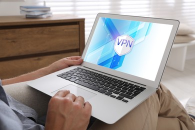 Man using laptop with switched on VPN indoors, closeup