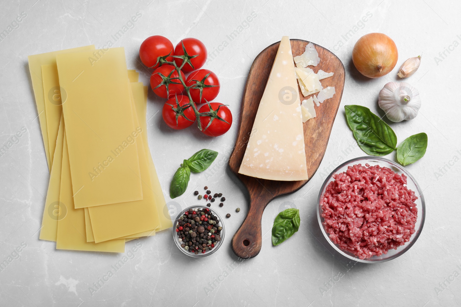 Photo of Fresh ingredients for lasagna on light grey marble table, flat lay